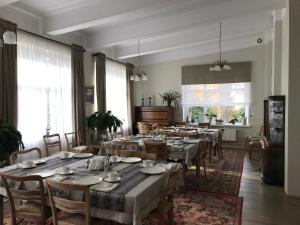 a dining room with tables and chairs and windows at Willa Sarna in Międzyzdroje