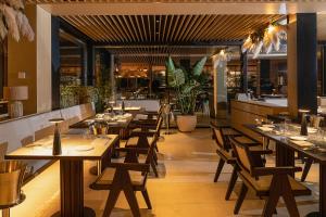 un ristorante con tavoli e sedie in legno e un bar di Dimora dei Lari a Bacoli