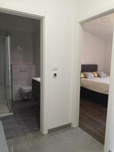 - une chambre avec un lit et une salle de bains avec des toilettes dans l'établissement Apartments Tanja, à Kaštela