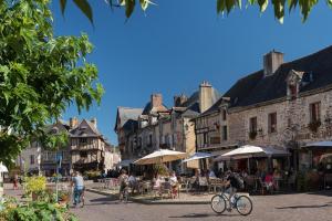 a group of people riding bikes down a street with buildings at Duplex plein centre ville 10B in Malestroit