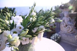 a vase filled with white flowers on a table at Hotel Villa Margherita in Quercianella
