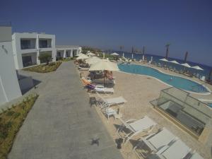 an overhead view of a pool with chairs and umbrellas at Royal Bay Suites in Kefalos