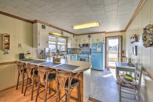 a kitchen with a island with bar stools in it at Nags Head Cottage Screened Porch, Walk to Beach! in Nags Head