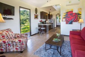 een woonkamer met een bank en een tafel bij Villa Vista Hermosa - with breathtaking ocean view & WiFI in Quepos