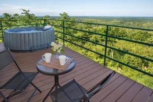 een tafel en stoelen op een terras met een hot tub bij Villa Vista Hermosa - with breathtaking ocean view & WiFI in Quepos