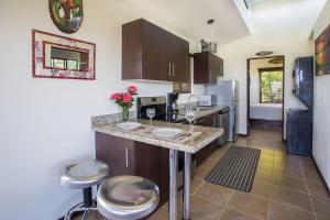 a kitchen with a counter and some stools in it at Villa Vista Hermosa - with breathtaking ocean view & WiFI in Quepos