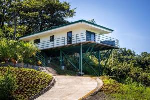 een huis op een heuvel met een loopbrug bij Villa Vista Hermosa - with breathtaking ocean view & WiFI in Quepos