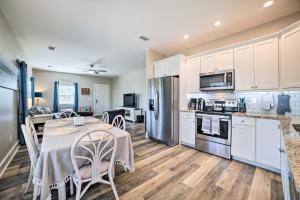 a kitchen and dining room with a table and appliances at Mexico Beach Getaway with Patio - Steps to Beach! in Mexico Beach