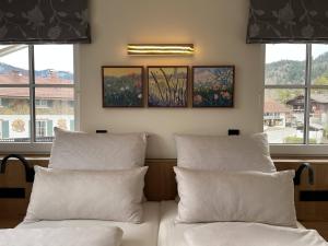 2 Betten mit Kissen in einem Zimmer mit Fenstern in der Unterkunft Lake Life 9 in Bad Wiessee