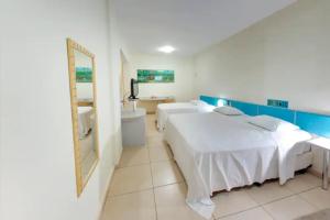 a bedroom with a bed and a sink and a mirror at Amazon Plaza Hotel in Cuiabá