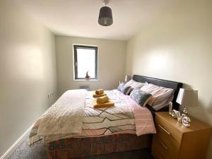 een slaapkamer met een bed met een hoed erop bij Lovely 2-Bedrooms Apartment Step to The Beach in Swansea