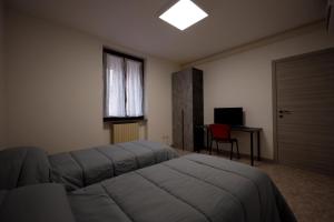 sypialnia z łóżkiem, biurkiem i oknem w obiekcie Placido's B&B w mieście Rho
