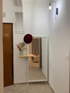 einen Flur mit einem Spiegel und einem Tisch in einem Zimmer in der Unterkunft ''Korifo apartment'' at Benitses in Benitses