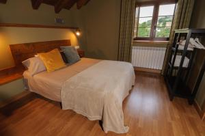a bedroom with a large bed with yellow pillows at Hostal Rural Iratiko Urkixokoa in Orbaiceta