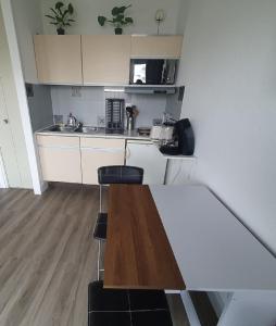 een keuken met een tafel en 2 krukken bij le studio paradis bleue in La Grande-Motte