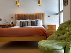 a bedroom with a bed and a green chair at Browns Hotel in Dartmouth