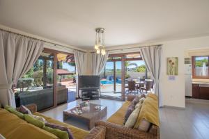 a living room with a couch and a tv at Villa Margarita in Protaras