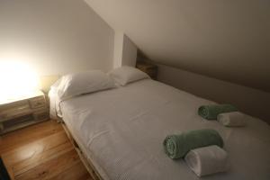 een slaapkamer met een bed met twee handdoeken erop bij Tiny House in Nazaré