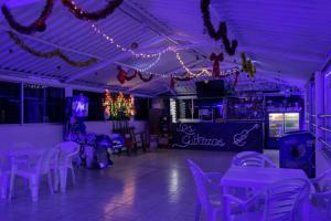 a dining room with purple lighting and tables and chairs at Club Recreativo Las Guitarras in Florián