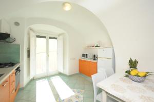 uma cozinha com uma mesa e uma cozinha com armários laranja em Campolillo House em Amalfi