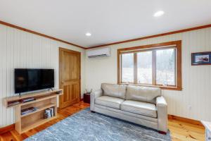 a living room with a couch and a flat screen tv at Dream Harbor House and Cottage in Surry