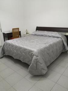 een bed met een wit dekbed in een kamer bij Tra Puglia e Basilicata in Montescaglioso