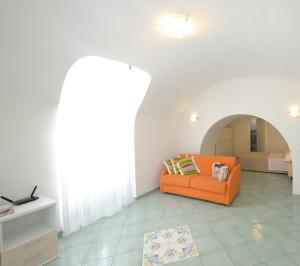 uma sala de estar com um sofá laranja num quarto em Campolillo House em Amalfi