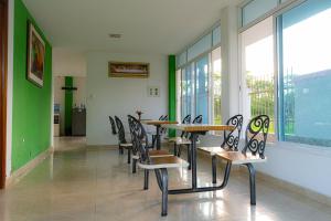 comedor con mesa, sillas y ventanas en HOTEL CAMPESTRE VILLAS de SANTA RITA, en Tauramena