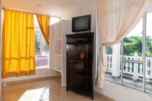 a television on a shelf in a room with windows at HOTEL CAMPESTRE VILLAS de SANTA RITA in Tauramena