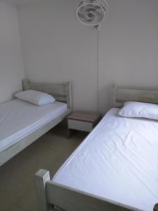 two twin beds in a bedroom with a fan at Apartamento en Ricaurte in Ricaurte