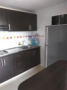 a kitchen with a sink and a refrigerator at Apartamento en Ricaurte in Ricaurte