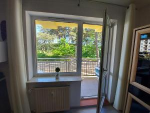 ein Fenster in einem Zimmer mit Blick auf einen Balkon in der Unterkunft Apartament z widokiem na las Na wydmie in Ustka