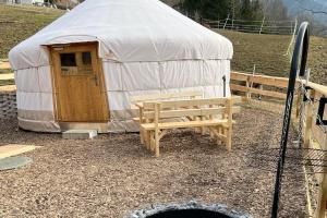 uma tenda com um banco e uma mesa à frente em Jurte beim Lama- & Alpakahof Triesenberg em Triesenberg