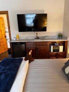 a bedroom with a bed with a large television on the wall at Enchantment Lodges - 5 min walk to downtown in Leavenworth
