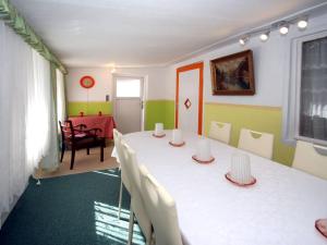 a room with a white table and chairs and a room with a red table at Bungalow garden idyll, Berlin in Berlin