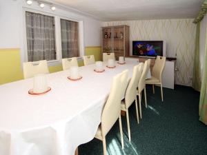 uma sala de conferências com uma grande mesa branca e cadeiras em Bungalow garden idyll, Berlin em Berlim