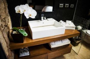 a bathroom with a sink and a flower on a counter at Hotel Boutique Casa Madero in Morelia