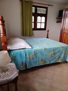 una camera da letto con un letto con un piumone blu di Au Soleil Couchant a Bouillante