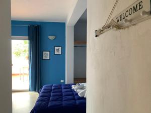 ein blaues Schlafzimmer mit einem Bett und einer blauen Wand in der Unterkunft La casa del vento Stagnone in Marsala