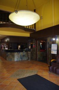 a lobby with a bar and a large light fixture at South Hill Lodge in Prince Albert