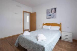 sypialnia z łóżkiem i dwoma ręcznikami na nim w obiekcie Karin House w mieście La Guancha