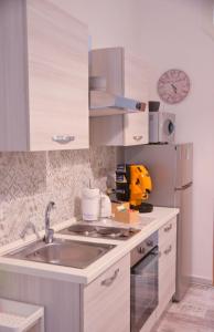 a kitchen with a sink and a refrigerator at CASA MARTINO FORMALE in Naples +11 photos