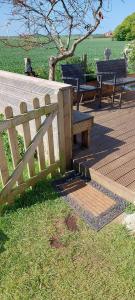 a wooden deck with benches and a fence at Bridlington's Bolt Hole chalet in Bridlington