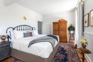 a bedroom with a large white bed and a rug at The Holbrooke Hotel in Grass Valley