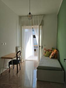 een slaapkamer met een bed, een tafel en een raam bij Casa Teresa in Castellaneta