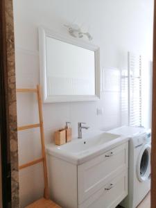ein weißes Badezimmer mit einem Waschbecken und einer Waschmaschine in der Unterkunft Casa Teresa in Castellaneta