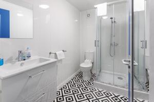 a white bathroom with a shower and a toilet at City Centre Studio 9 with Kitchenette, Free Wifi and Smart TV with Netflix by Yoko Property in Middlesbrough