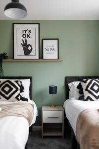 2 camas en una habitación con paredes verdes en City Centre Studio 9 with Kitchenette, Free Wifi and Smart TV with Netflix by Yoko Property en Middlesbrough