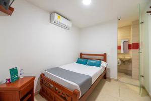 a bedroom with a bed and a bathroom with a shower at Hotel Nuevo Yalu in Barranquilla