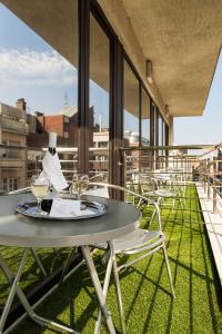 a table and chairs on a balcony with windows at Carat Boutique Hotel in Budapest